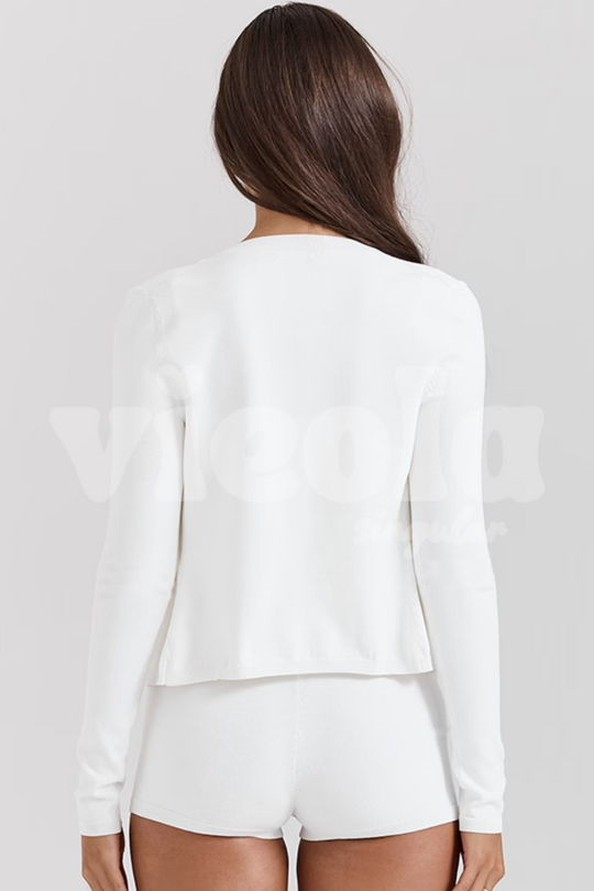 Person wearing a white long-sleeve top and shorts on a plain background