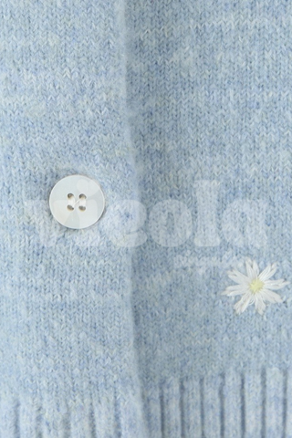 Light blue fabric with a button and white flower design