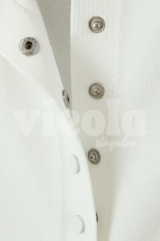 Close-up of a white shirt with metallic buttons on a light gray background